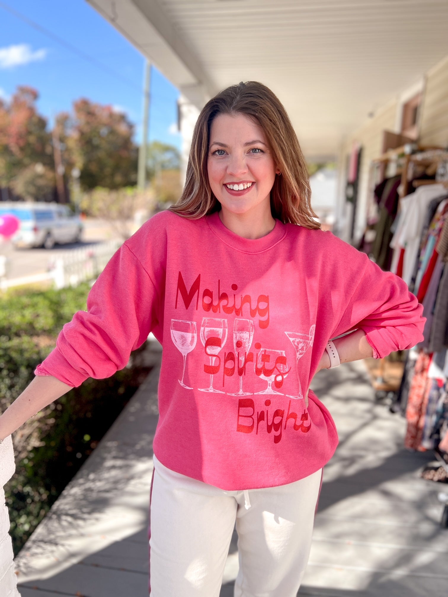 bright pink sweatshirt with "making spirits bright" written on the front. also includes spirited drinks on the front such as a martini.